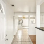 View of a bright, empty hallway with beige tiled floor